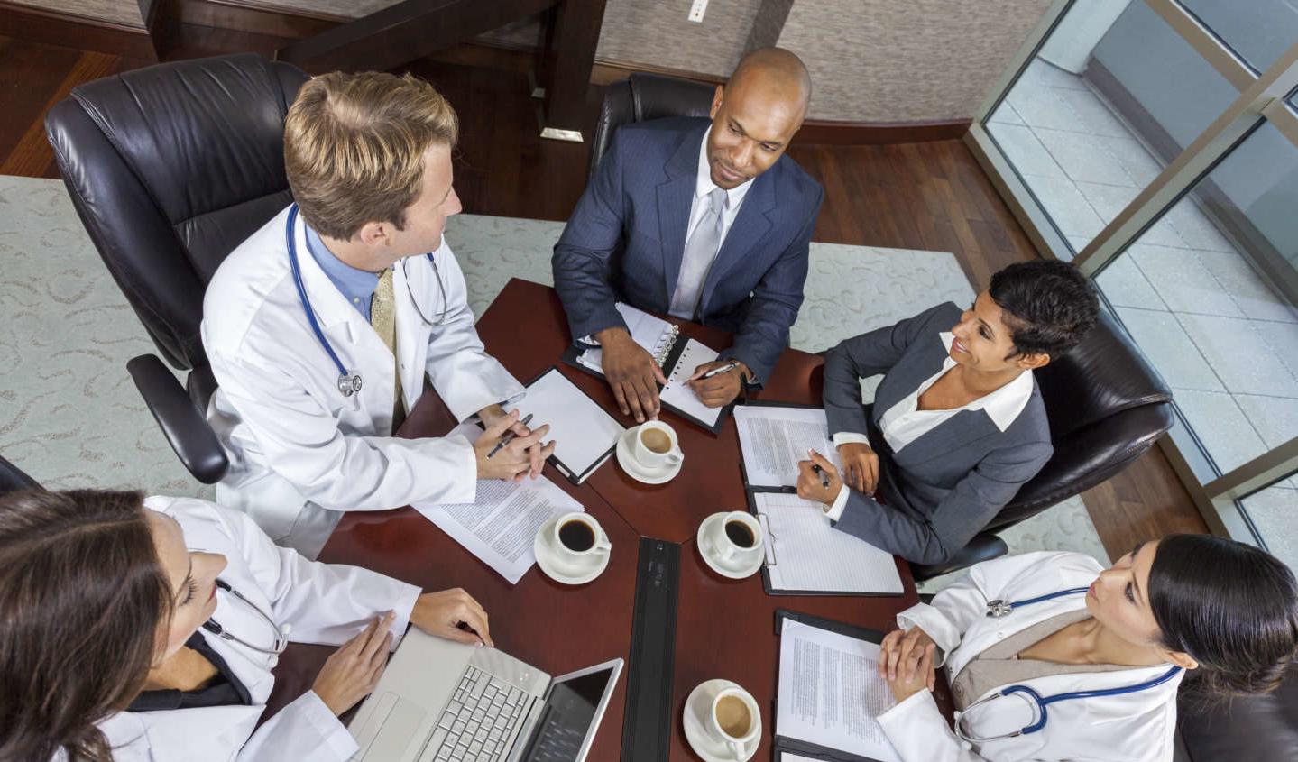 Top view of healthcare professionals and administrators in an morning meeting.